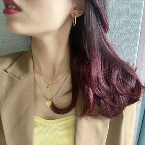 Detail of elegant double-layered gold necklace with circular pendants and geometric earrings