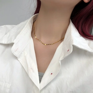Collana minimalista placcata in oro 14k con maglie rettangolari su camicia bianca
