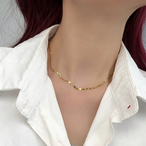 Dettaglio della collana a catena geometrica placcata oro 14k su modella elegante
