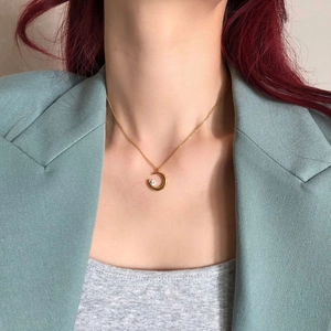 Minimalist gold moon necklace with single zircon stone shown on a female model