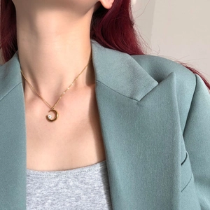 Detailed close-up of a crescent moon necklace with a polished gold finish and zircon stone