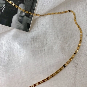 Collana a maglie quadrate piatte placcata oro 14k su tessuto di lino bianco chic