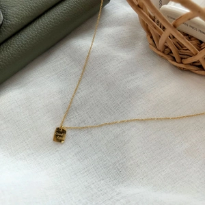 Makroaufnahme der quadratischen 14k Goldhalskette mit Good Luck Gravur-Detail