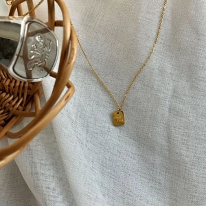 Detailaufnahme der 14k vergoldeten Good Luck Halskette mit quadratischem Anhänger