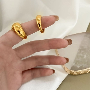Polished minimalist gold dome rings on fingers with white silk background