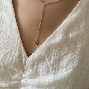 Collier en Y minimaliste en or 18 carats avec pendentif étoile sur robe dentelle