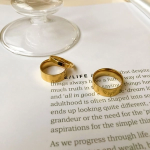 Three-piece gold plated stainless steel ring set with minimalist polished finish on paper