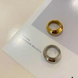 Detailweergave van brede gepolijste goud- en zilveren ringen met geometrische texturen