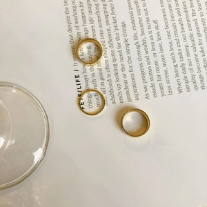 Detailed close-up of wide and thin polished gold rings on an open book background