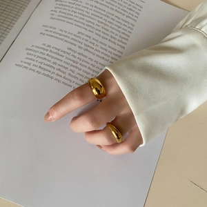 Polished gold minimalist ring set featured on a model's hand with fashion magazine background