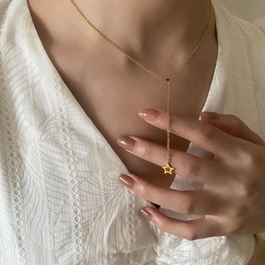 Collier minimaliste en Y doré avec pendentif étoile de mer ajouré porté par un mannequin