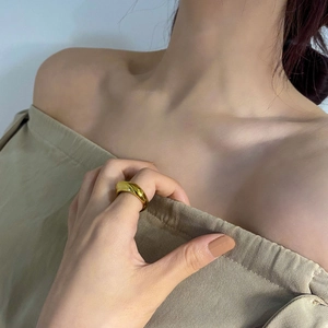 Close-up van een onregelmatige goudkleurige ring op de vinger met elegante textuur