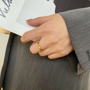 Detail of 18k gold plated stainless steel ring with vertical grooves worn by a model
