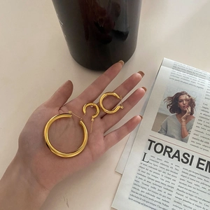 Three-piece set of polished golden hoop earrings in small medium and large sizes