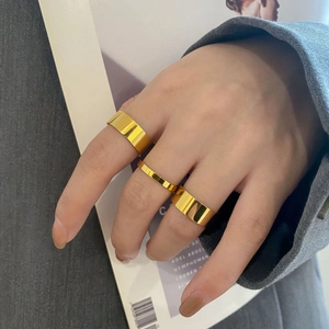 Three-piece minimalist gold-plated titanium steel rings shown on a hand with a grey blazer