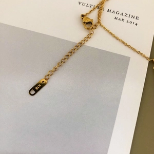 Détail macro du collier plaqué or 18 carats avec fermoir mousqueton et étiquette K18
