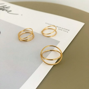Three-piece gold minimalist intertwined multi-layer stackable ring set on magazine