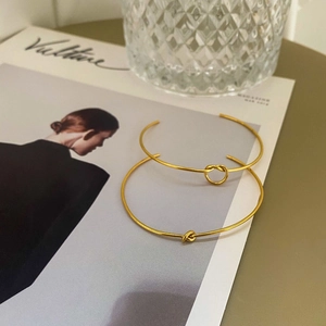 Elegant gold-tone knot open cuff bracelet set displayed on a lifestyle background