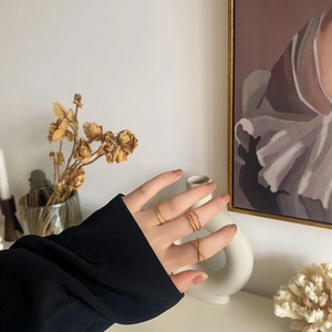 Close-up of minimalist layered gold rings with crisscross and parallel line designs