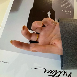 Detail of a gold geometric faceted ring styled with a modern fashion magazine background