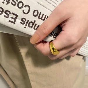 Detailaufnahme eines hochglanzpolierten goldenen Siegelrings im minimalistischen Design