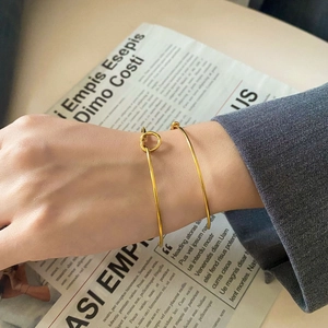 Detail shot of minimalist knot gold bracelets on wrist with urban chic styling