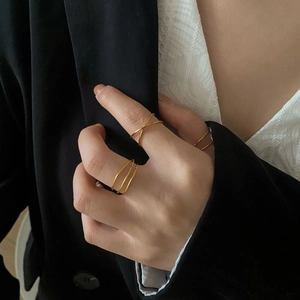 Detail of minimalist gold-plated multi-layer rings stacked on model's fingers