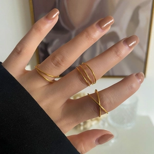 Close-up of golden multi-layer rings with minimalist crisscross design and sleek metal finish