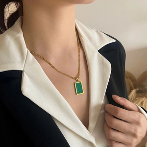 Elegante collana d'oro con ciondolo rettangolare in malachite verde su modella