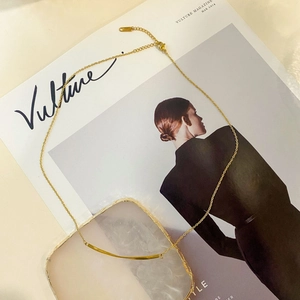 Minimalistische Goldkette mit gebogenem Anhänger und verstellbarer Kette auf Beige-Tablett