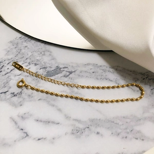 Detail of 18K gold plated oval bead bracelet with lobster clasp and K18 engraving