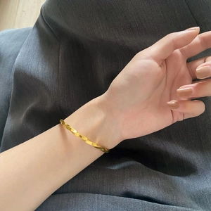 Minimalistisches Mobius-Armband aus 18K vergoldetem Titanstahl am Handgelenk getragen