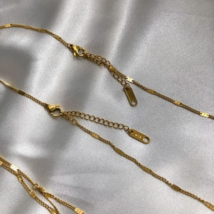 Détail du collier superposé doré avec fermoir mousqueton, chaîne d'extension et gravure K18