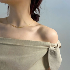Minimalistische gebogene Goldhalskette am Hals des Models für Länge und Hauttonvergleich