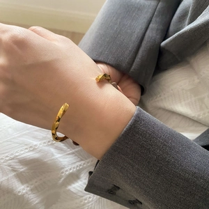 Detailansicht eines goldenen gedrehten Mobius-Armreifs mit elegantem Business-Look