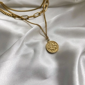 Collana dorata a tre strati con ciondolo a moneta e catena grossa su seta bianca