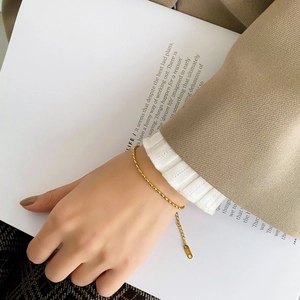 Detail of elegant gold beaded bracelet with 18K engraving and adjustable chain links