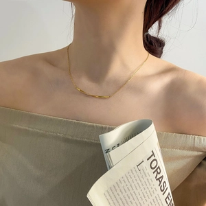 Detailansicht der minimalistischen goldenen Kette mit gedrehtem Anhänger am Schlüsselbein