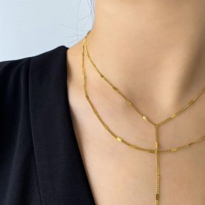 Détail d'un ensemble de colliers dorés à deux rangs en Y au style moderne et minimaliste