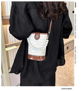 Detail of stone pattern mini bucket bag with pearl handle and metal clover logo