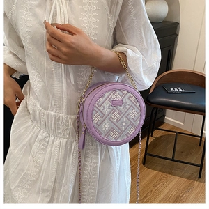 Détail du sac rond violet avec broderie géométrique et bandoulière de perles