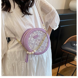 Detail of round lavender crossbody bag with geometric embroidery and pearl charms