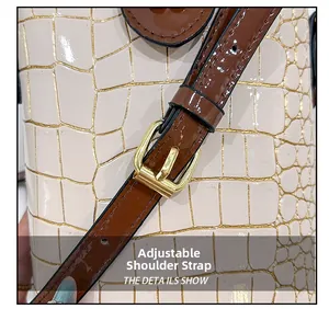 Detail of adjustable shoulder strap with gold buckle on stone pattern bucket bag