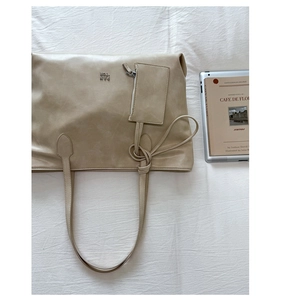 Top view of beige large PU tote bag with matching mini pouch and metal logo detail