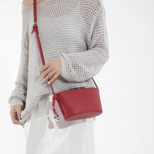 Red lychee pattern shoulder bag with FASHION embossing and heart pendant on model