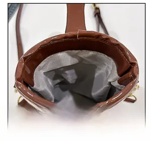 Detail view of the brown stone pattern bucket bag showing the grey herringbone fabric lining
