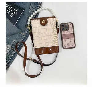 Detail of stone pattern bucket bag with pearl handle and metal clover logo buckle