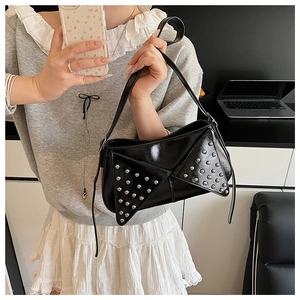 Close-up of black punk shoulder bag with silver rivets worn by a model in a mirror selfie