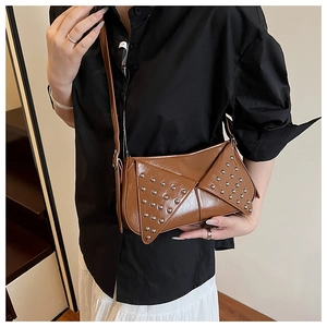 Close-up of caramel glossy patent leather crossbody bag with silver rivet details