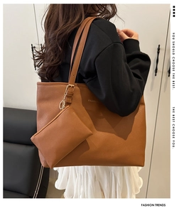 Detail view of the brown leather tote bag with a small pouch and FASHION lettering